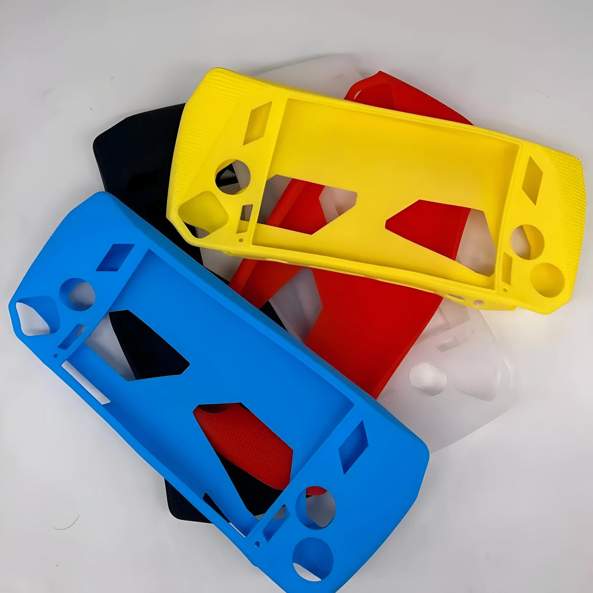 Plastic game console case with drop protection, shown in black, blue, pink, red, white, or yellow
