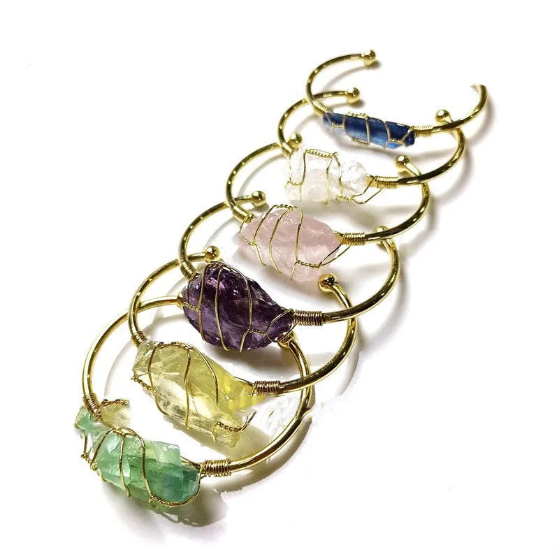 Natural gold winding crystal rough stone bracelet with unshaped geometric design on a wrist.