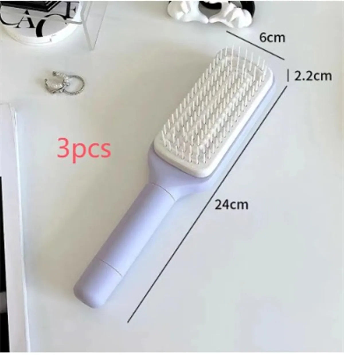 Purple and grey self-cleaning hair brush with rotating handle for easy debris removal
