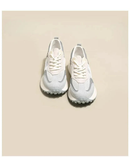 Women's grey low-top retro sneakers with mesh lining and round toe on a flat rubber sole.