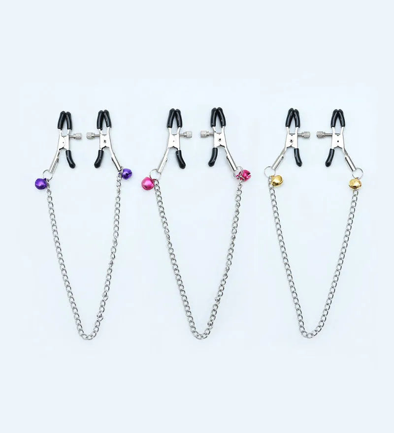 Red and purple nipple clamps with small bells and feather decorations for adult sensory play.