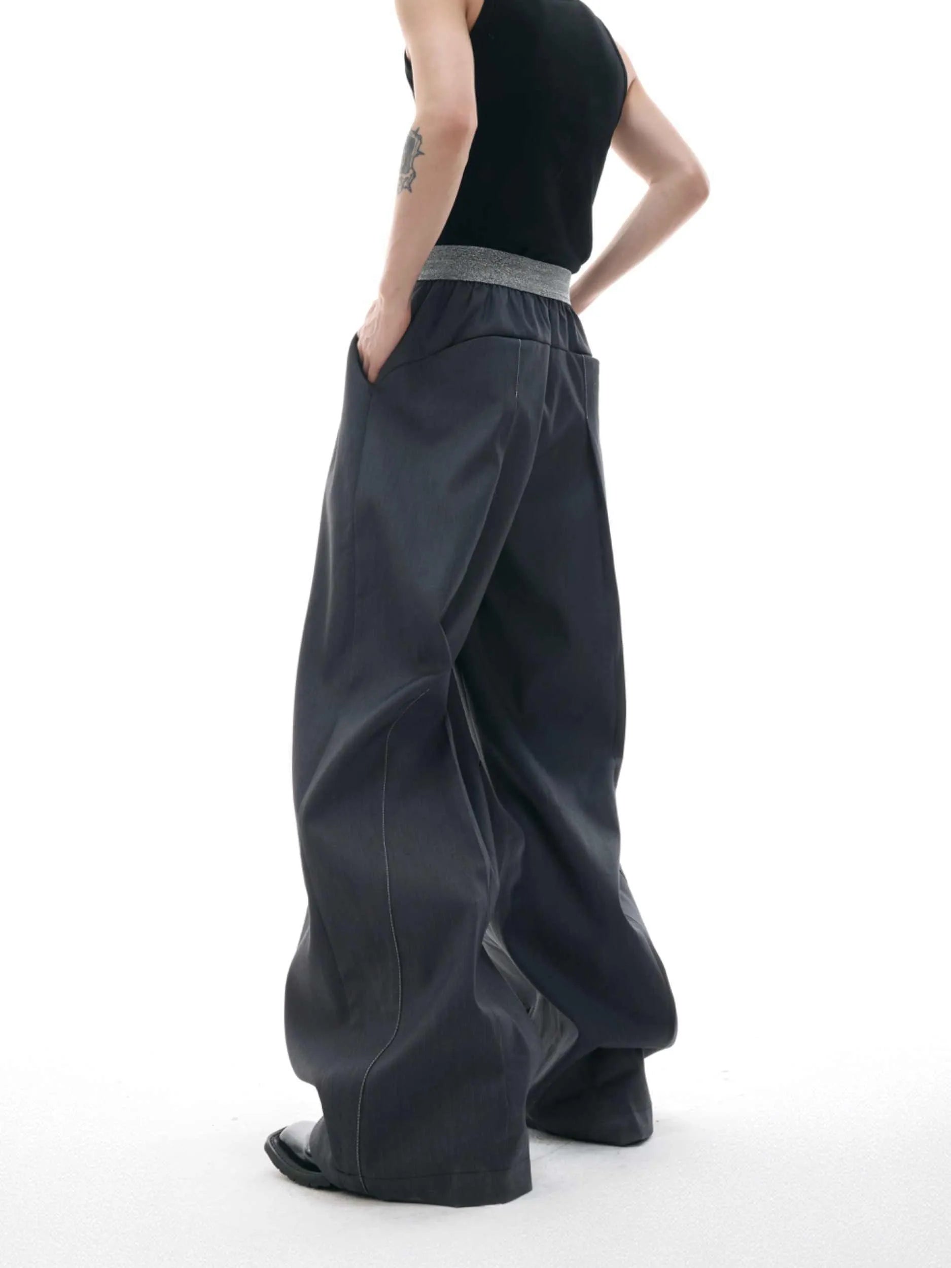 Straight-leg trousers with button-open line detail in black and grey colours, showing high-waist design and tailored silhouette