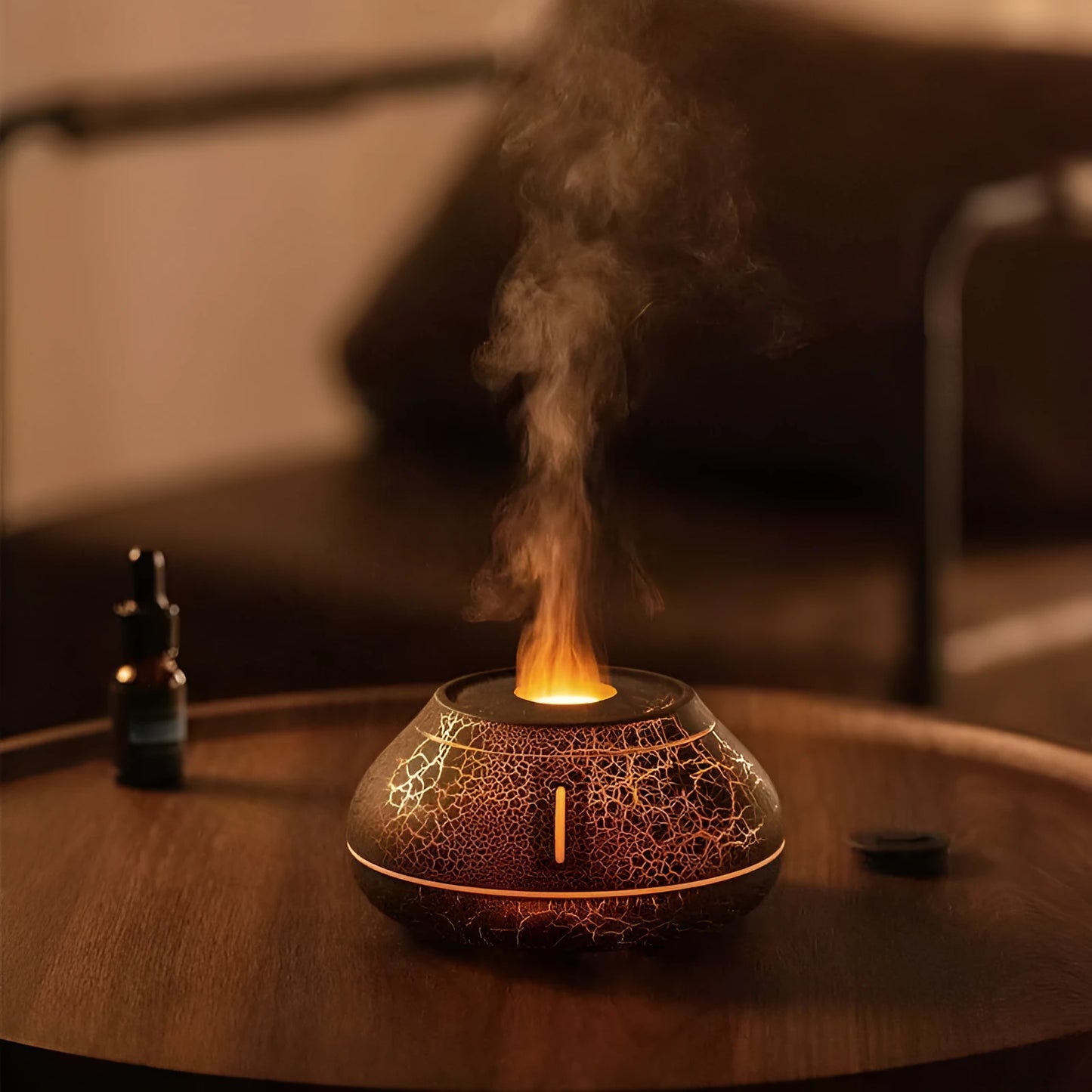 White rounded desktop aroma diffuser with colourful flame-like light and mist plume on a wooden table.