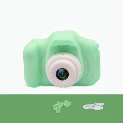 X2 HD mini digital camera for kids in silicone case with lanyard, shown capturing photo on 2-inch screen.