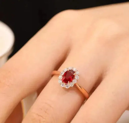 Gold pigeon and floral design women's ring with red gemstone inlay on a silver band.