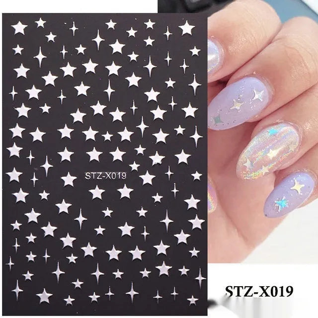 Assortment of black and silver nail sticker designs including cartoon and French tip patterns on a plastic sheet.