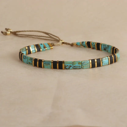 Geometric glass beaded pull bracelet in multiple colours including milky white, black, retro green, light blue, and red