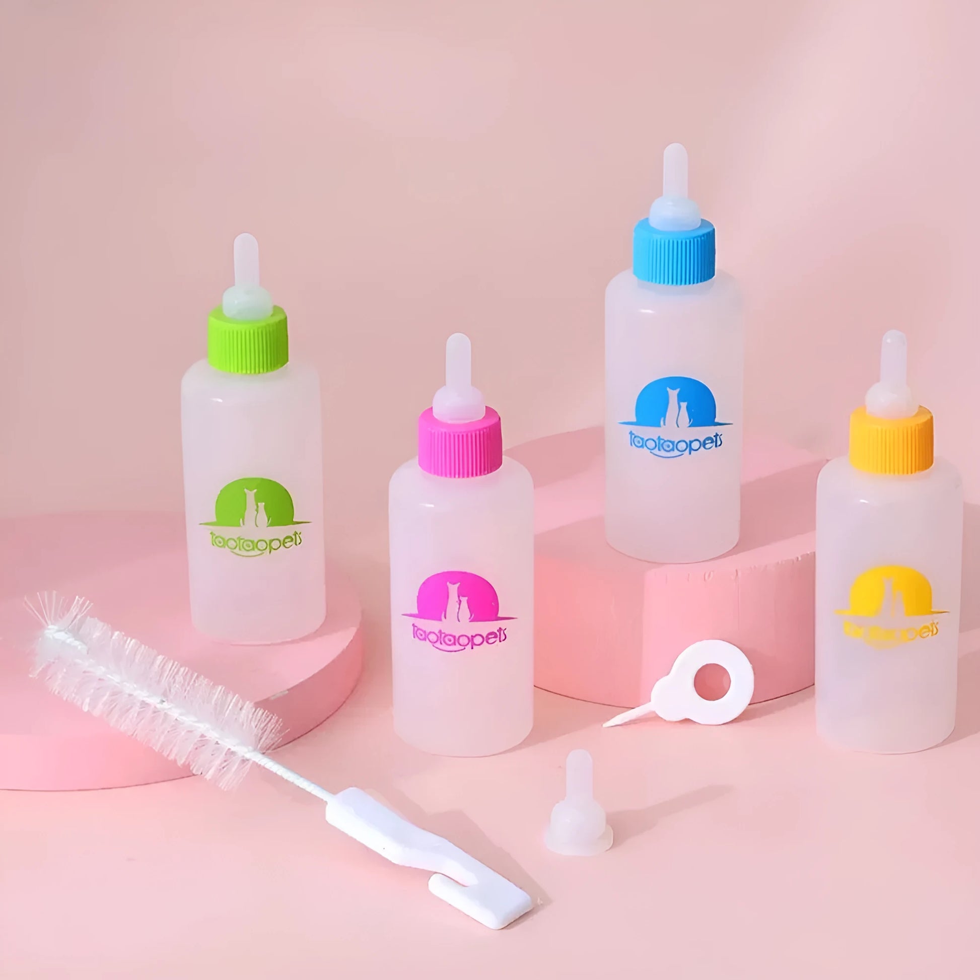 Set of four coloured pet milk bottles with silicone teats and a cleaning brush for small animals.