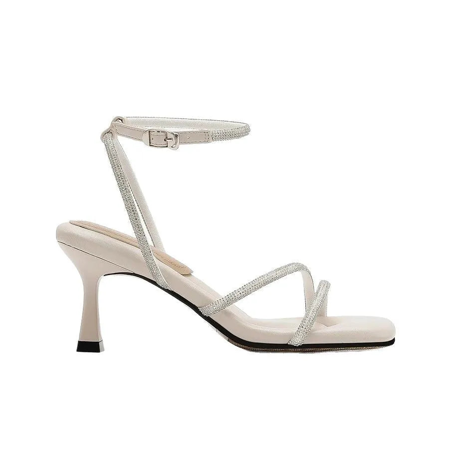 Women's silver rhinestone sandals with square toe and ankle strap buckle on a white background.
