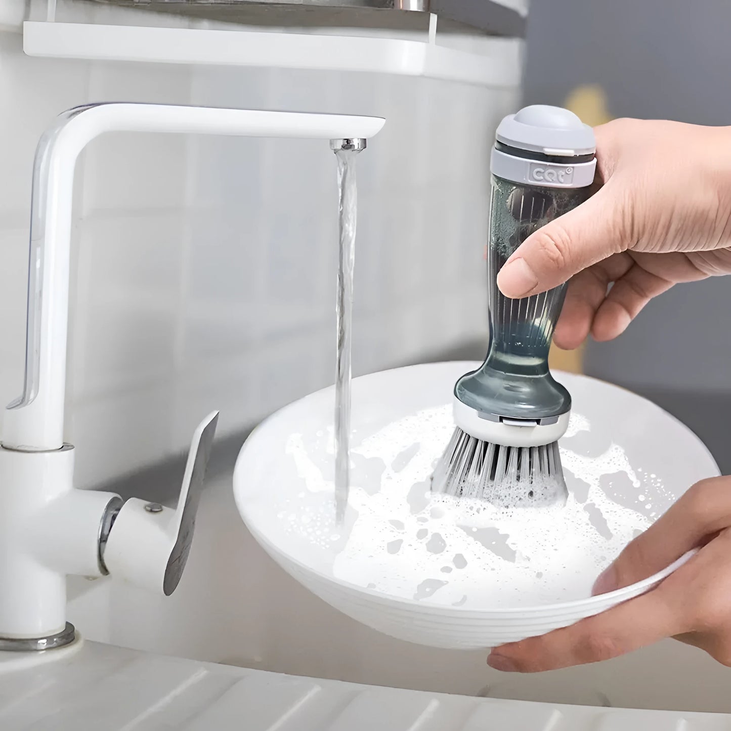 Milk white and mint green pot scrub brush with a soap dispenser handle and replaceable non-scratch bristles.