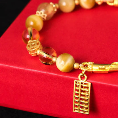 Women's handmade beaded bracelet with diamond-shaped tigereye and citrine abacus tag, yellow tower crystals, and copper details.