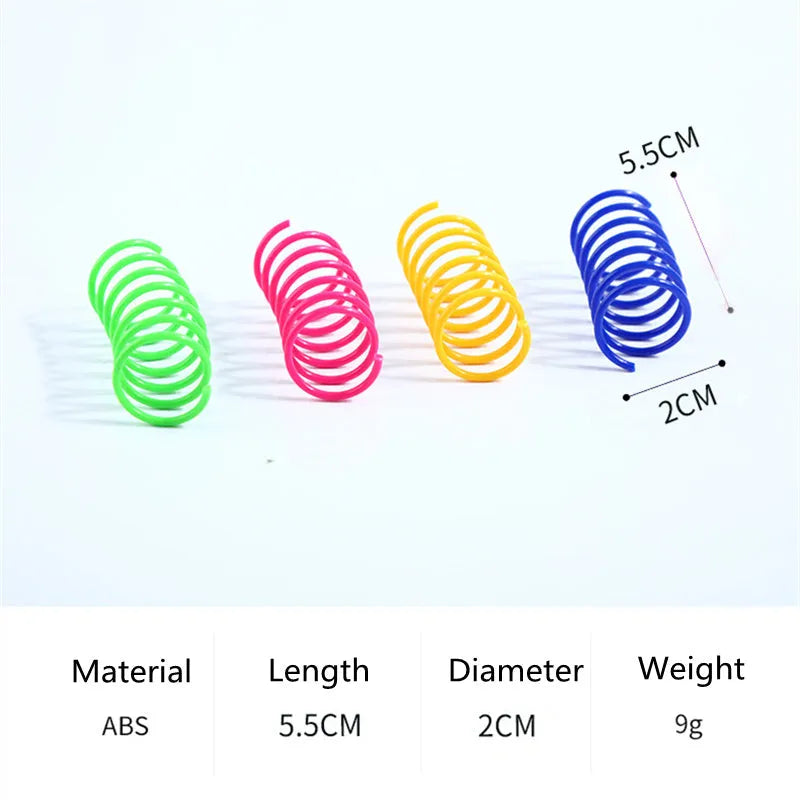 Assortment of colourful plastic coil spring toys for cats on a plain surface.