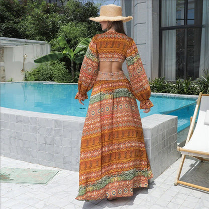 Elegant floral print dress with long sleeves and empire waistline in vibrant orange color
