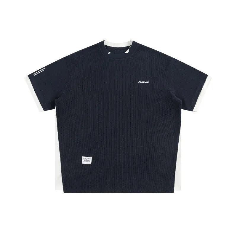 Loose fit waffle fabric T-shirt with retro alphabet embroidery on the chest, shown in navy blue.