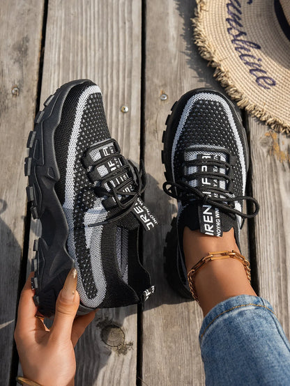 Women's Flyknit mesh lace-up sneaker in a grey colourway showing round toe and rubber sole.