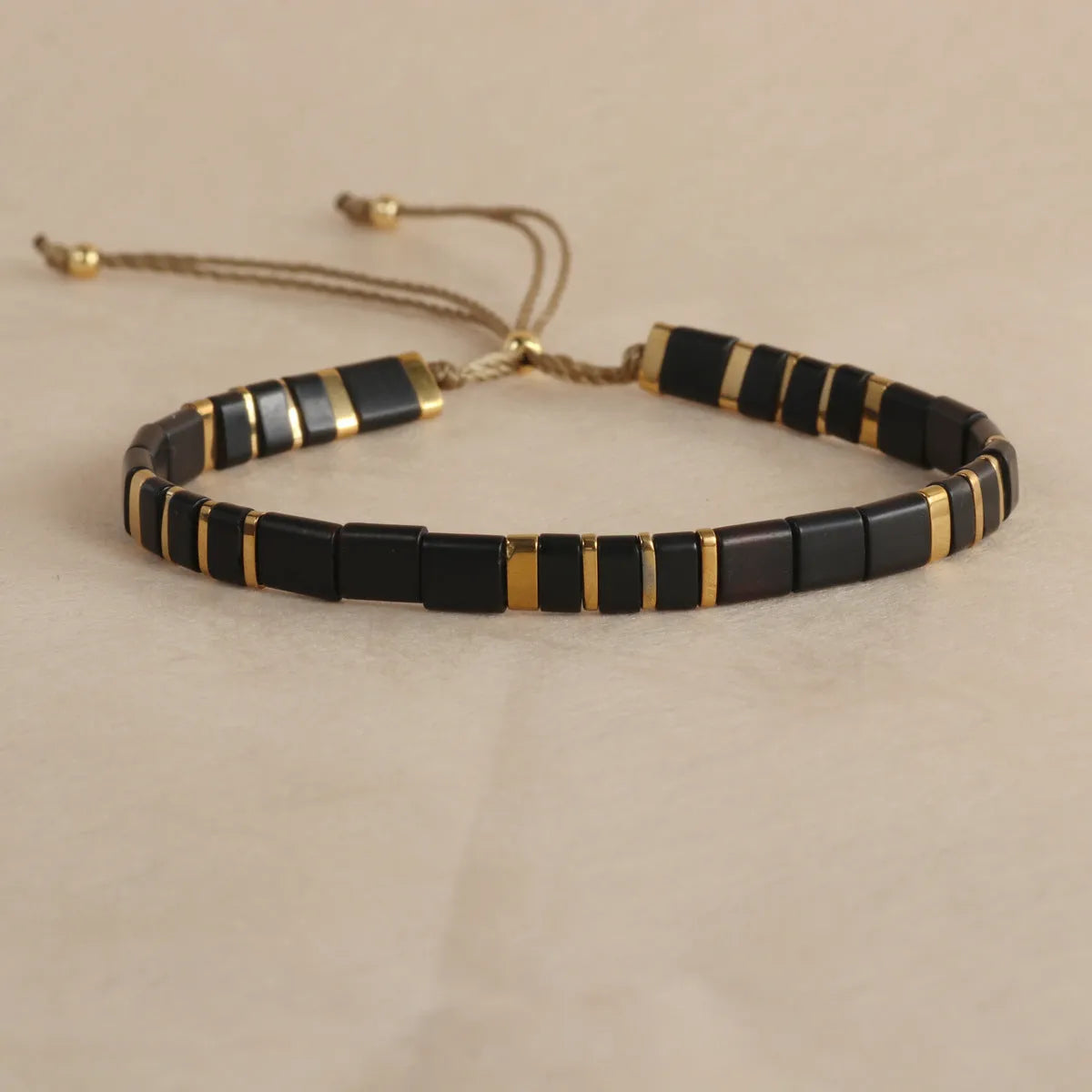 Geometric glass beaded pull bracelet in multiple colours including milky white, black, retro green, light blue, and red