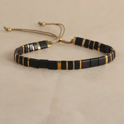 Geometric glass beaded pull bracelet in multiple colours including milky white, black, retro green, light blue, and red
