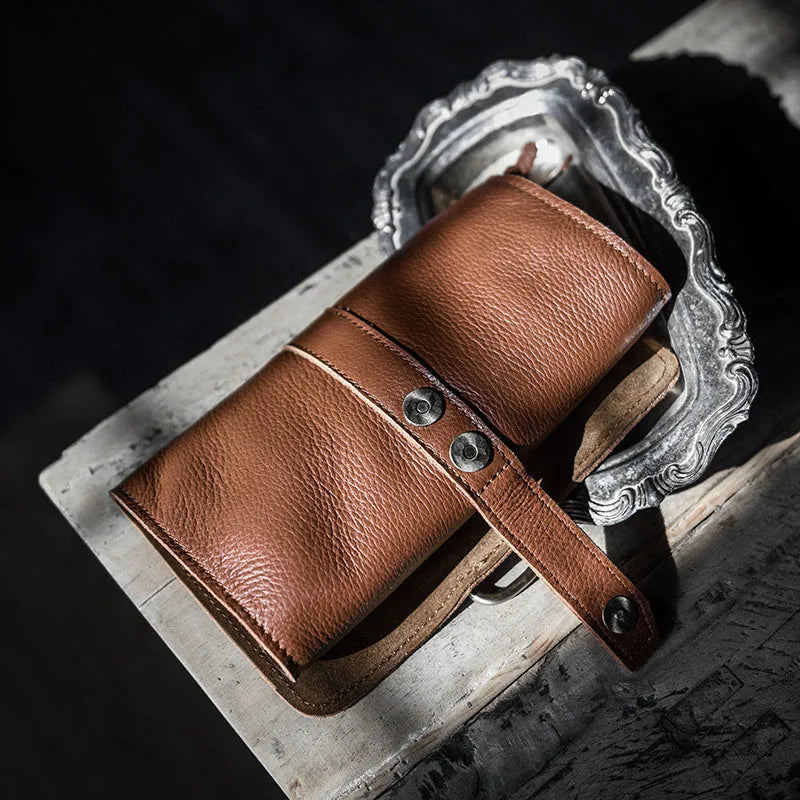 Handmade vintage leather wallet in black or dark brown with tape closure.