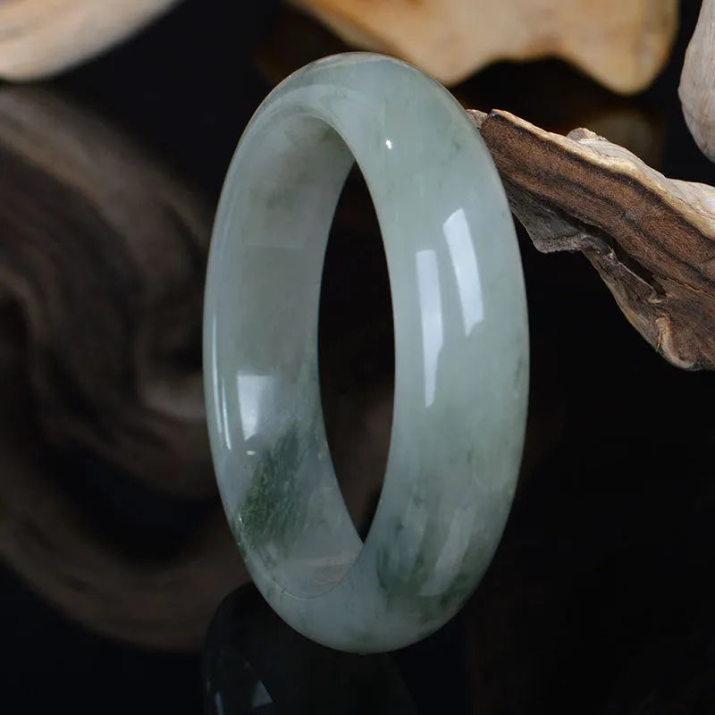 Natural Jinsi Jade Chinese bracelet in a closed bangle design on a plain background.
