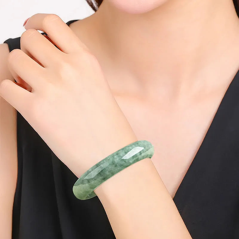 Natural deep pea green jade bracelet on wrist, simple style with certificate and gift box.