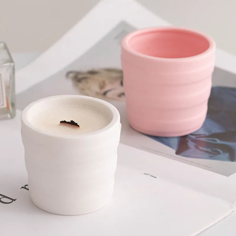 Set of ten round white ceramic candlesticks with minimalist relief patterns on a dining table