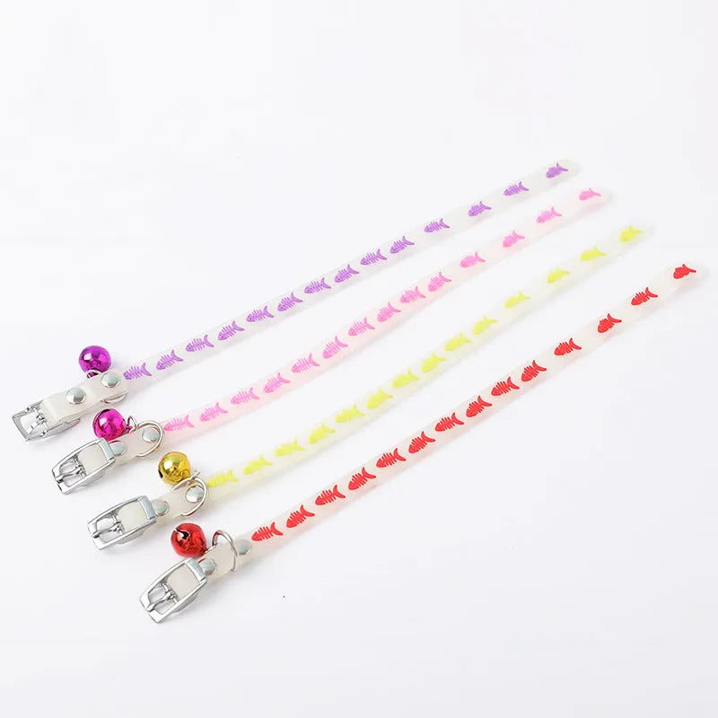 Glowing adjustable luminous collar for cats on a dark background, showing silicone chain and metal bell.