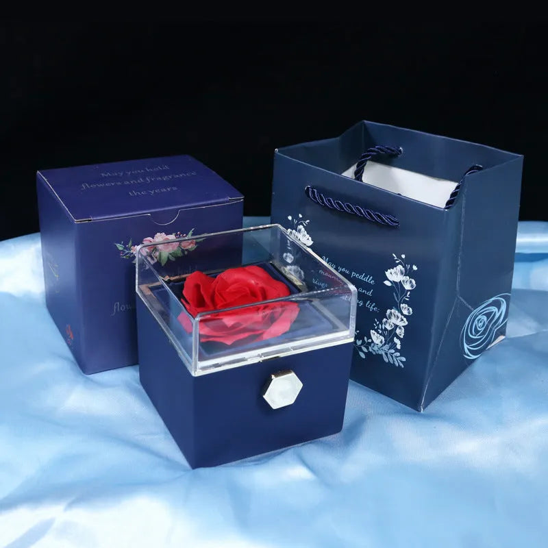 Rotating rose jewellery gift box with a preserved red rose under a clear acrylic dome, showing the interior rotating drawer.