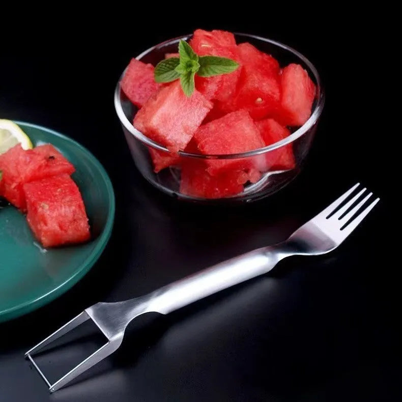 Stainless steel watermelon slicer and serving fork on a kitchen counter.