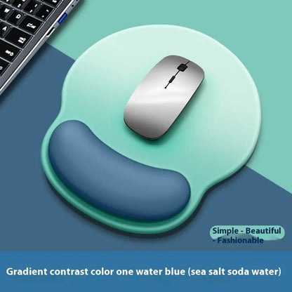 Silicone mouse mat with integrated wrist rest in a gradient blue black colour on a desk.