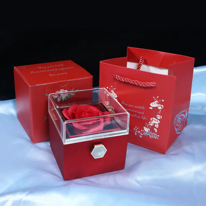 Rotating rose jewellery gift box with a preserved red rose under a clear acrylic dome, showing the interior rotating drawer.