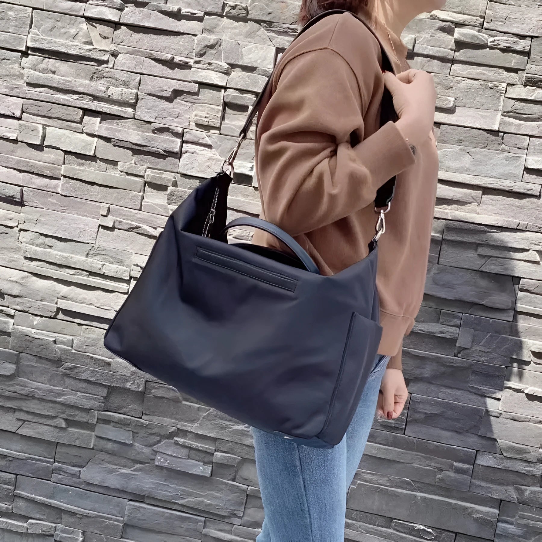 Waterproof nylon shoulder bag with leather accents in black or light khaki, showing 35cm width.