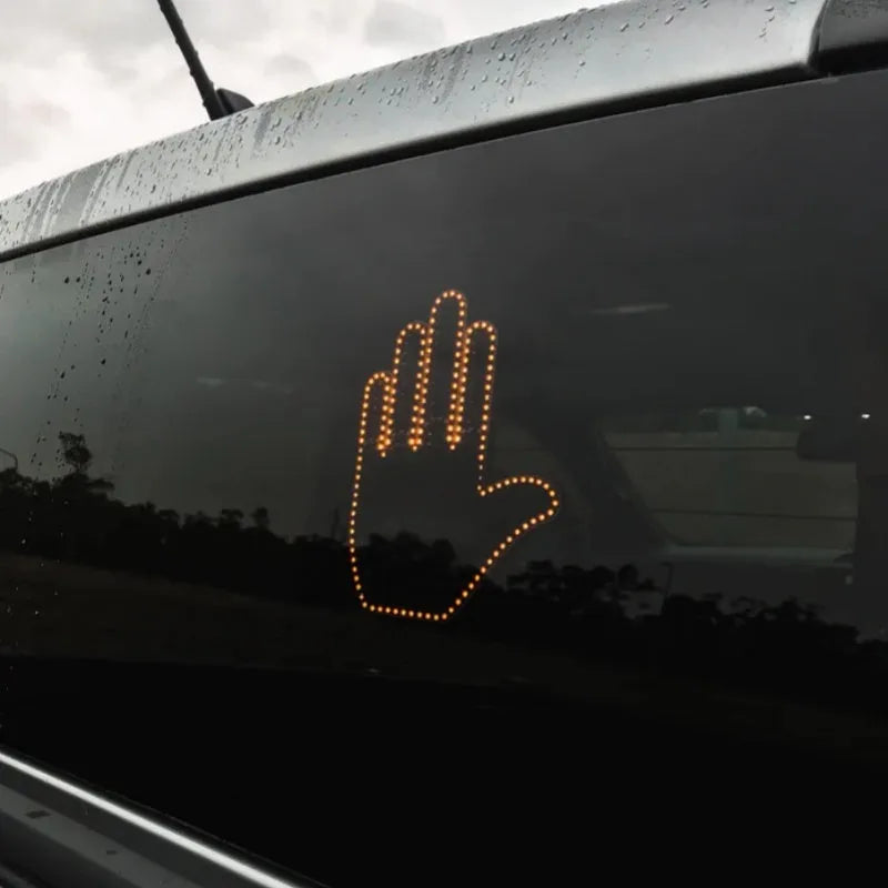 Black plastic LED gesture car light showing illuminated hand symbol, with remote control.