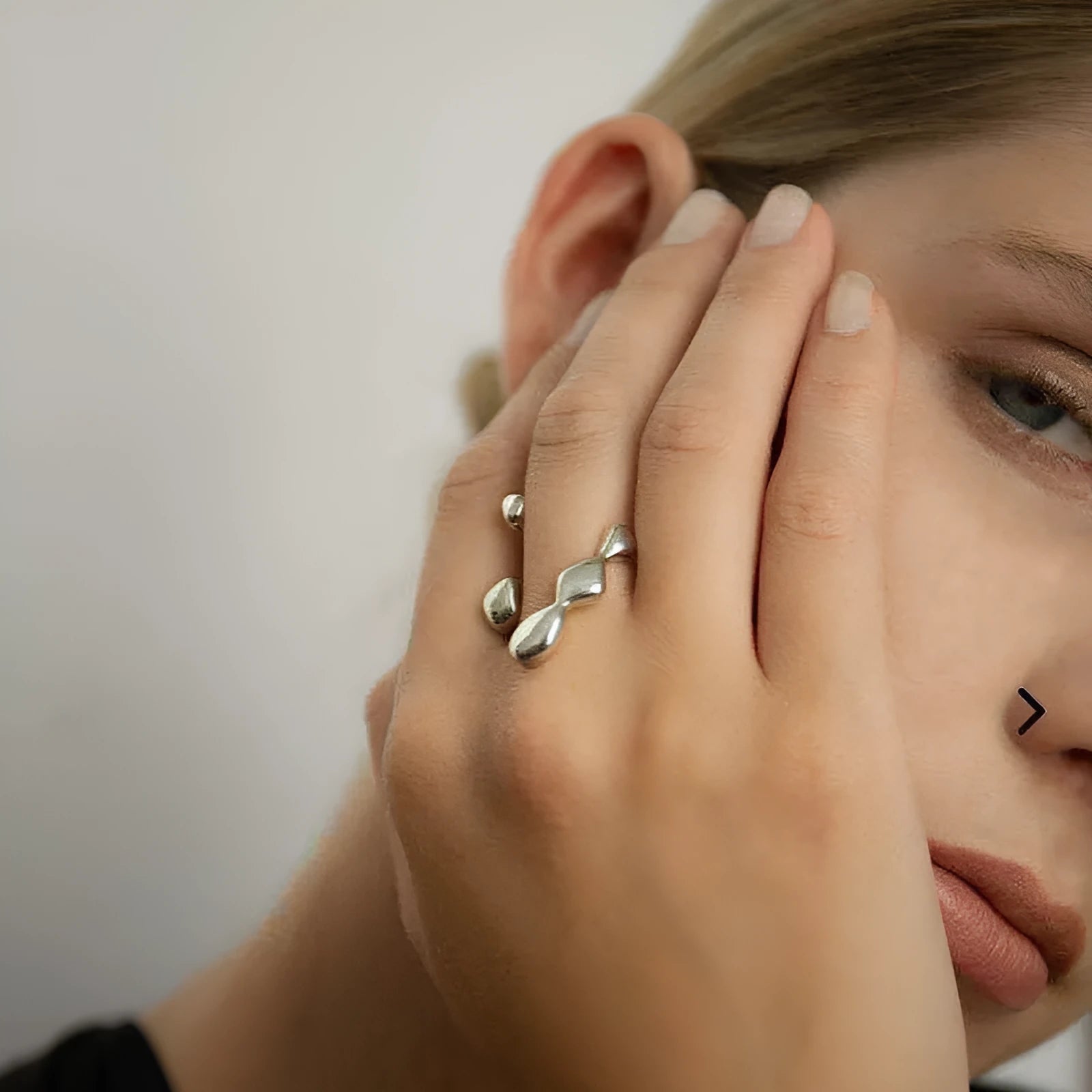 A minimalist brass ring with a small spherical detail on a plain band, shown in gold tone.