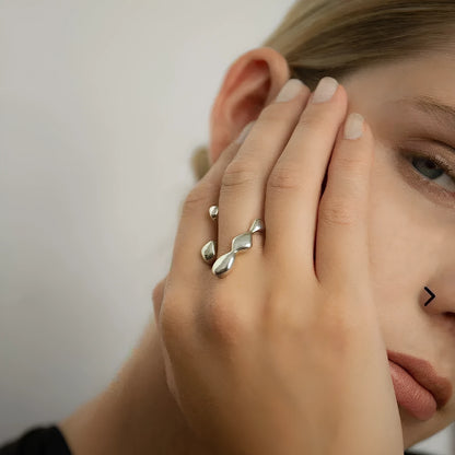Gold adjustable open ring with spherical details on a woman's hand, showing the 1cm gap.