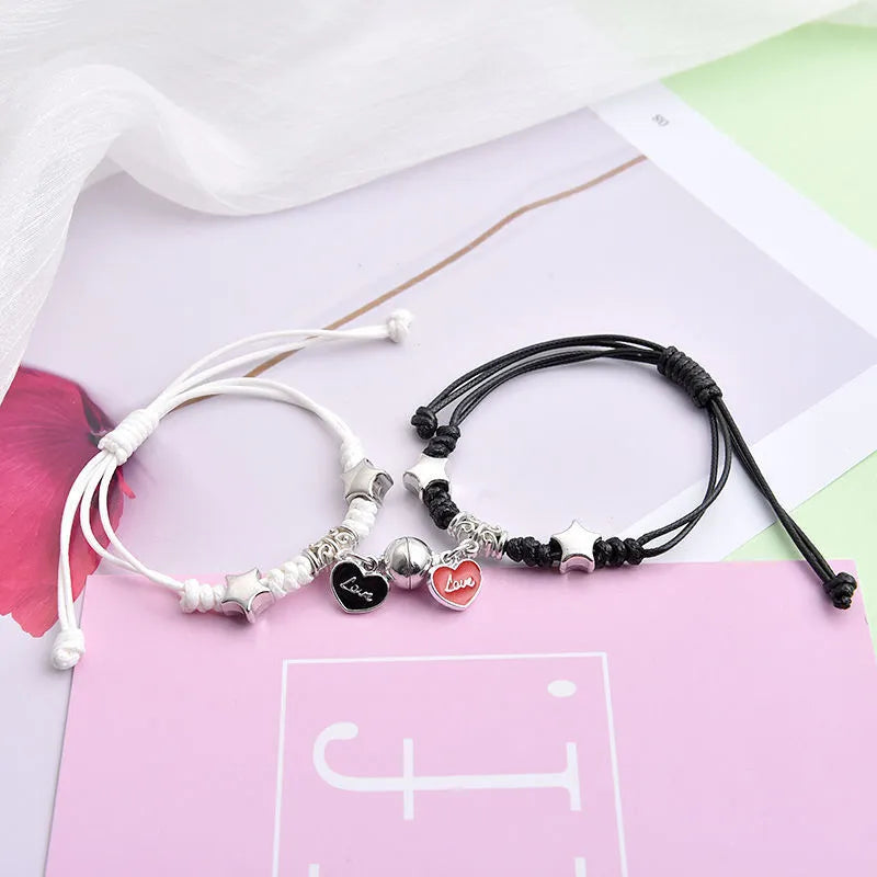 A pair of magnet couple bracelets with a suction clasp, showing various design options like clovers, crowns, and hearts.