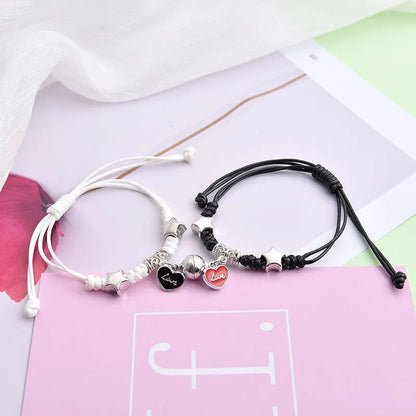 A pair of magnet couple bracelets with a suction clasp, showing various design options like clovers, crowns, and hearts.