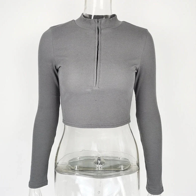 Women's black zip-front crop top with slim fit and long sleeves on hanger