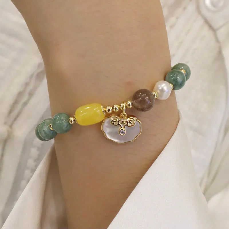 Light green jade bead bracelet with a shell charm and adjustable metal clasp.