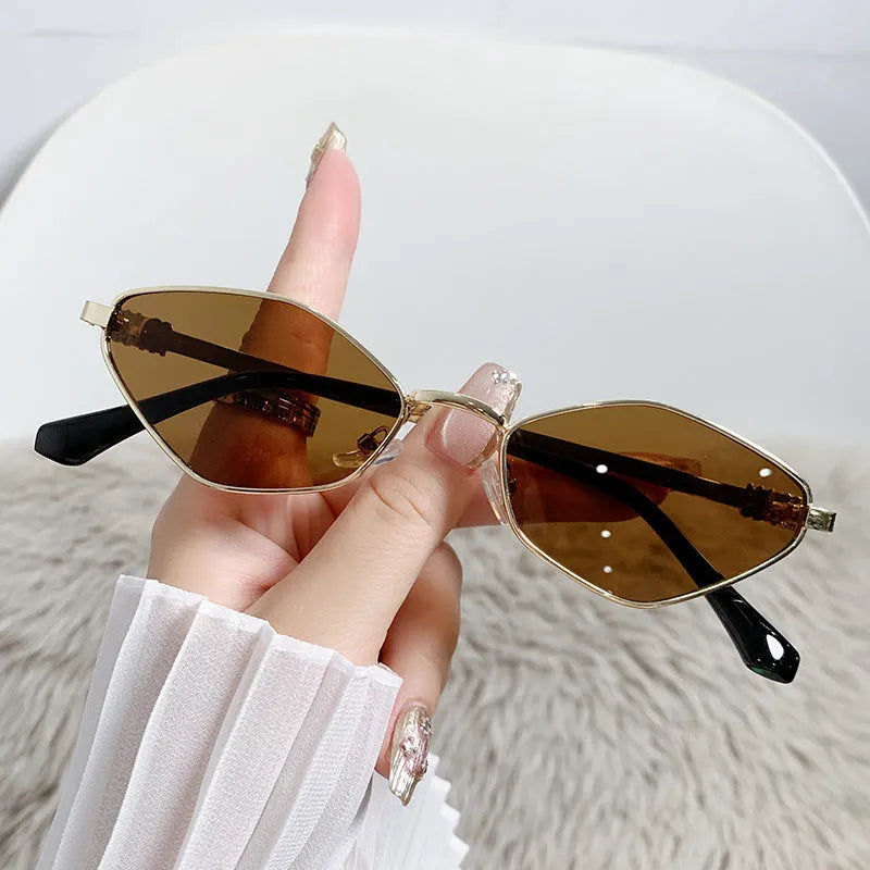 Gold metal frame rhombus-shaped cat eye sunglasses on a neutral background.
