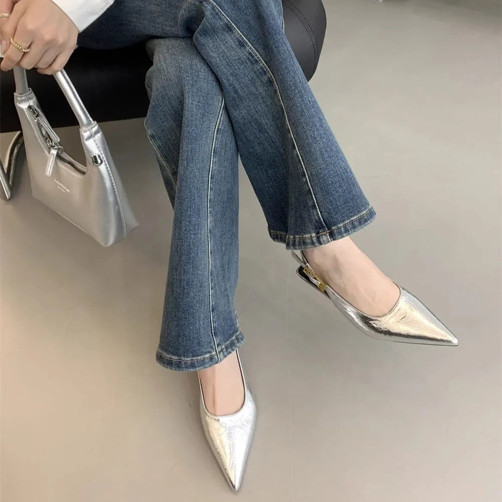 Women's black leather pointed toe shoes with low heel and thin strap.