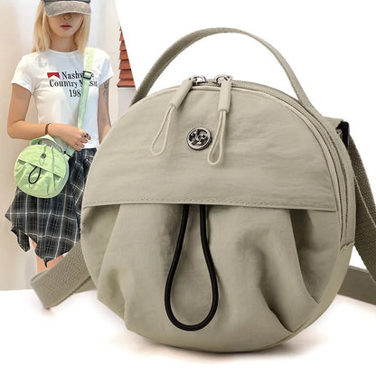 Out shoulder crossbody messenger bag in nylon showing interior zipped changing bag, phone pocket, and document compartment.