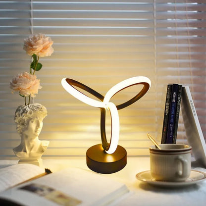 Black remote-controlled LED night light with Bluetooth remote on a bedside table.