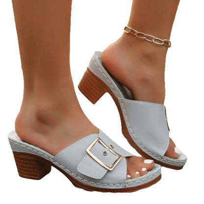 Women's black chunky heel slippers with a metal buckle and round toe, on a rubber sole