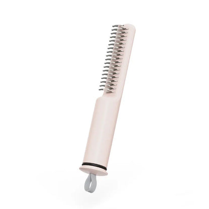 Pink and white stainless steel dematting comb for dogs on a plain background.