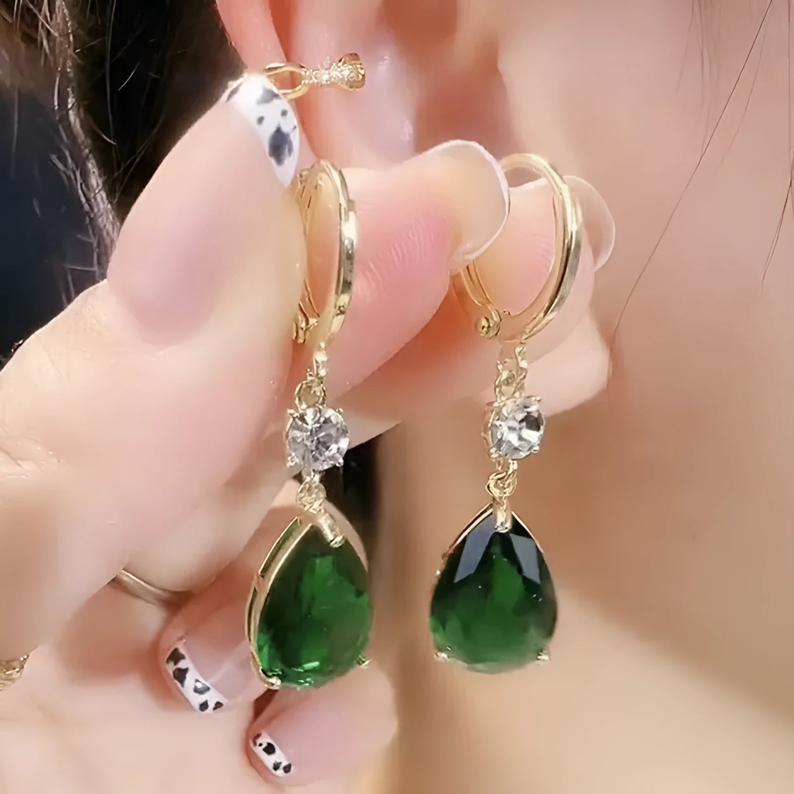 A pair of emerald green geometric teardrop drop earrings made from alloy