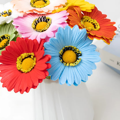 Silk artificial flower bouquet in a white polyurethane pot on a wooden table.