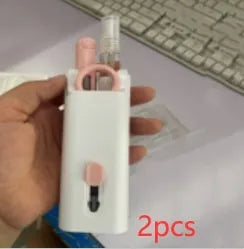 White electronics cleaning kit with a cleaning pen, spray bottle, brush, and keycap puller on a table