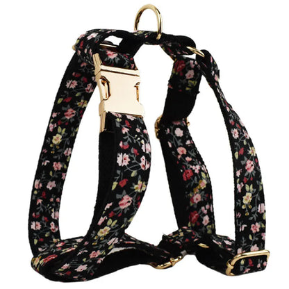 Four-piece dog accessory set showing a cloth collar, leash, vest, and removable bow with printed lettering.