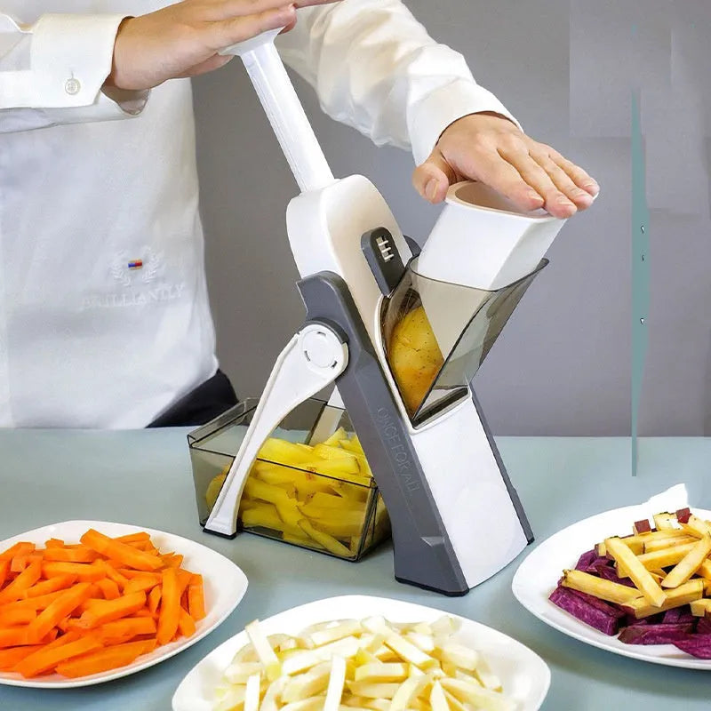 Orange multifunctional vegetable cutter kitchen tool with mandoline blades on a countertop.
