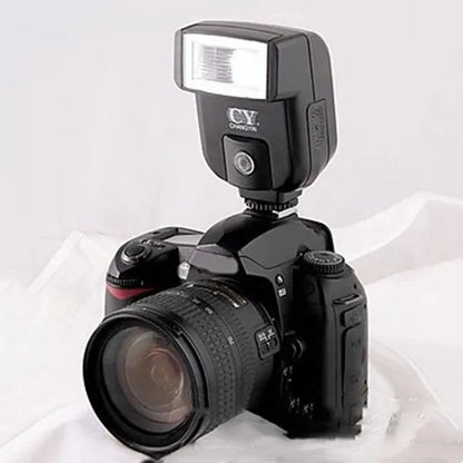 Compact black hot shoe camera flash with its head tilted upwards, showing the flash bulb and hot shoe mount.